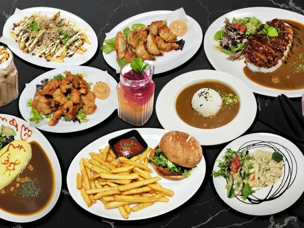 A spread of Arcane Maid Café dishes including curry rice, fried chicken and a burger