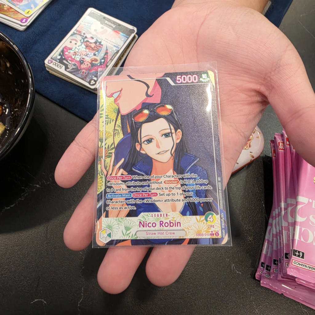 Nico Robin Leader EB05-010 Heroine Leader Alternate Art, Green/Yellow Leader with yellow flower frame, sleeved in hand, One Piece Card Game EB-05 Heroines Edition vol.2 pull at Arcane Maid Cafe, Arcadia CA
