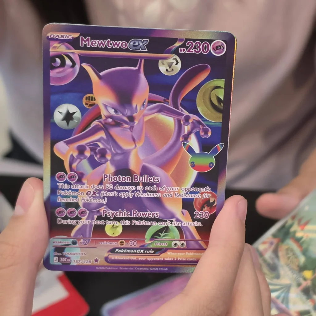Mewtwo ex 157/128 full art card from Pokémon 30th Celebration held up at Arcane Maid Café