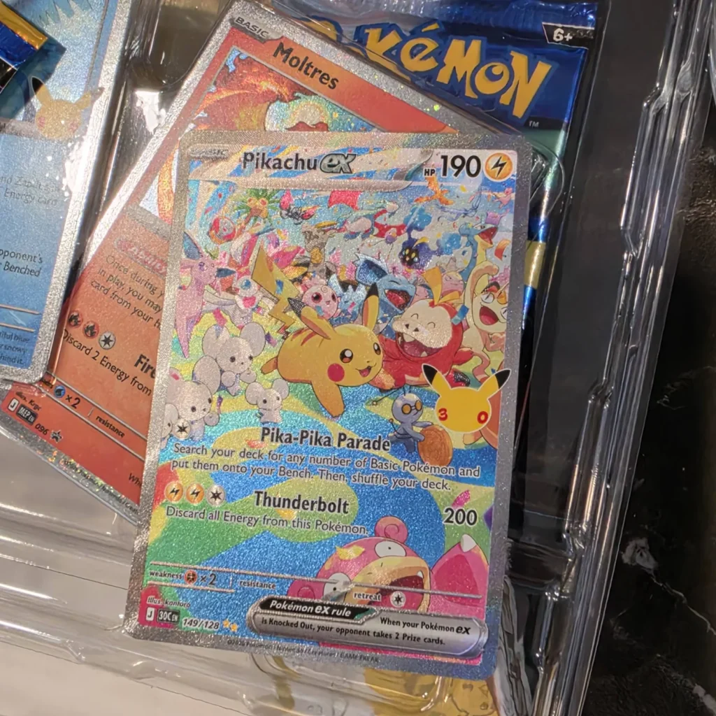Pikachu ex 149/128 special art card with the 30th logo from Pokémon 30th Celebration, next to a Moltres card, pulled at Arcane Maid Café